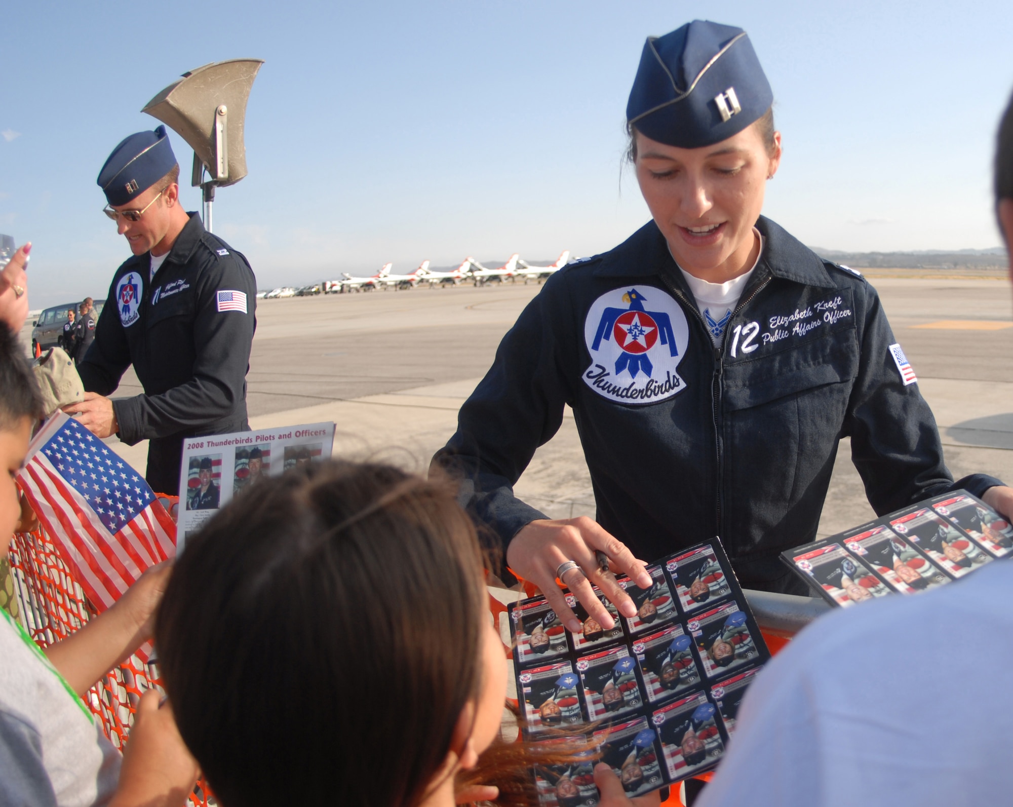 Capt. Elizabeth Kreft (right), Thunderbirds' public affairs officer, and Capt. Gifford Ploetz, Thunderbirds' maintenance officer, both from the U.S. Air Force Air Demonstration Squadron, Nellis Air Force Base, Nev., signs autograph during AirFest '08 at March Air Reserve Base, Calif., May 4, 2008. The May 3-4 air show, called "Thunder Over the Empire," attracted about 400,000 visitors to the base. It coincides with the 90th anniversary of March as a military base and the 60th anniversary of the Air Force Reserve.(U.S. Air Force photo by Val  Gempis)