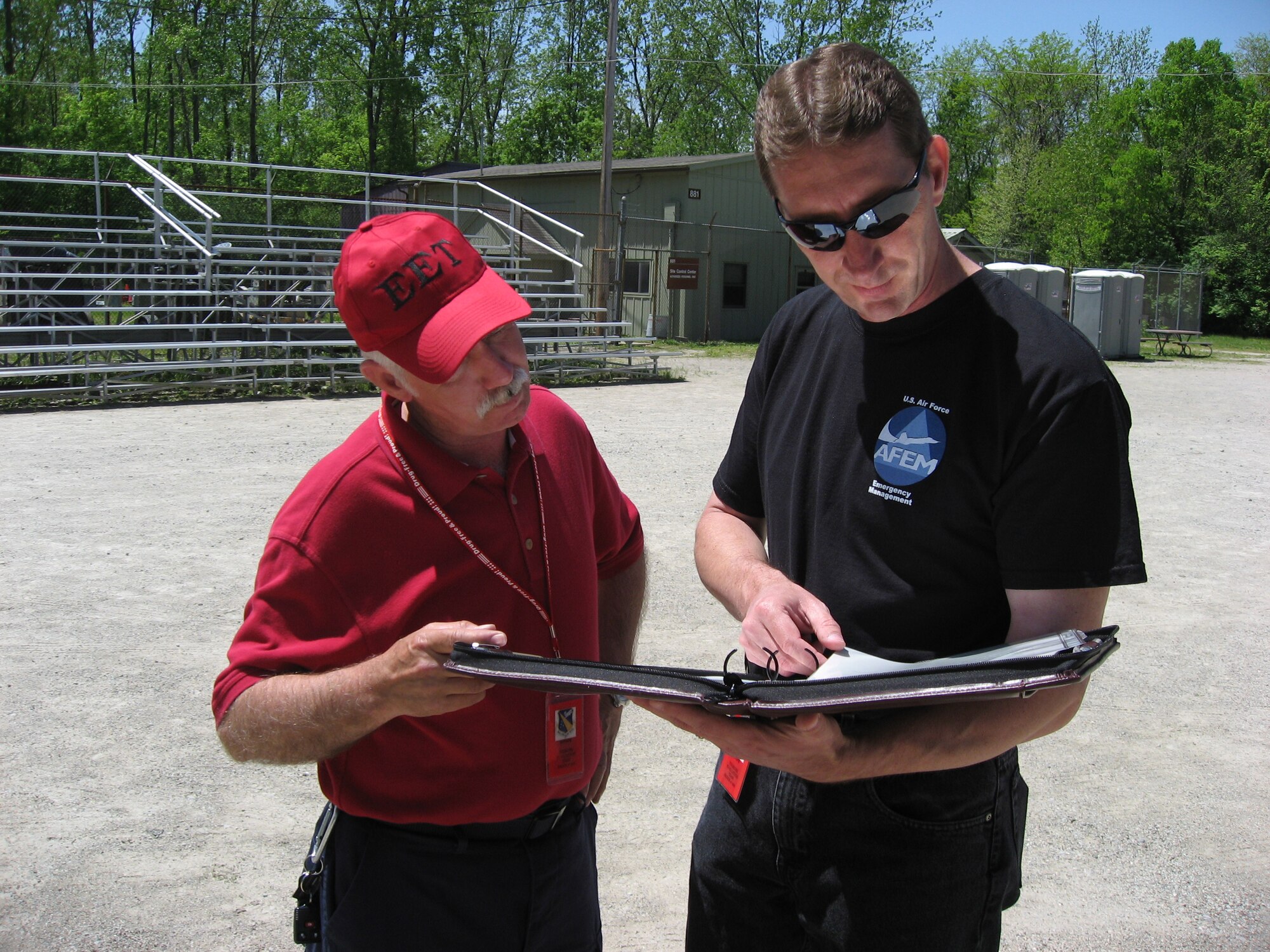 Floyd Johnson, 88th Air Base Wing Services Division exercise evaluation team member reviews the master scenario event list with Gene Jones, 88th Air Base Wing Emergency Management Flight training manager, during an employment exercise at Wright-Patterson Air Force Base, Ohio May 13.  (U.S. Air Force photo/Derek Kaufman)