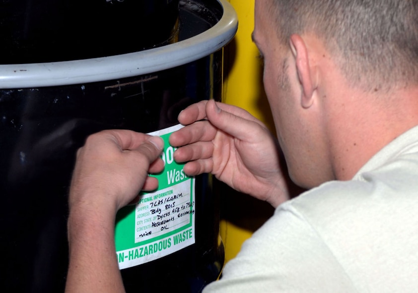 Dyess AFB, Texas - Staff Sergeant Dana Fox, 7th Logistics Readiness Squadron, places a label on a drum, May 14. All drums containing waste must identifiable with the proper labels whether its non-hazardous, hazardous, or universal. U.S. Air Force photo by Courtney Richardson)