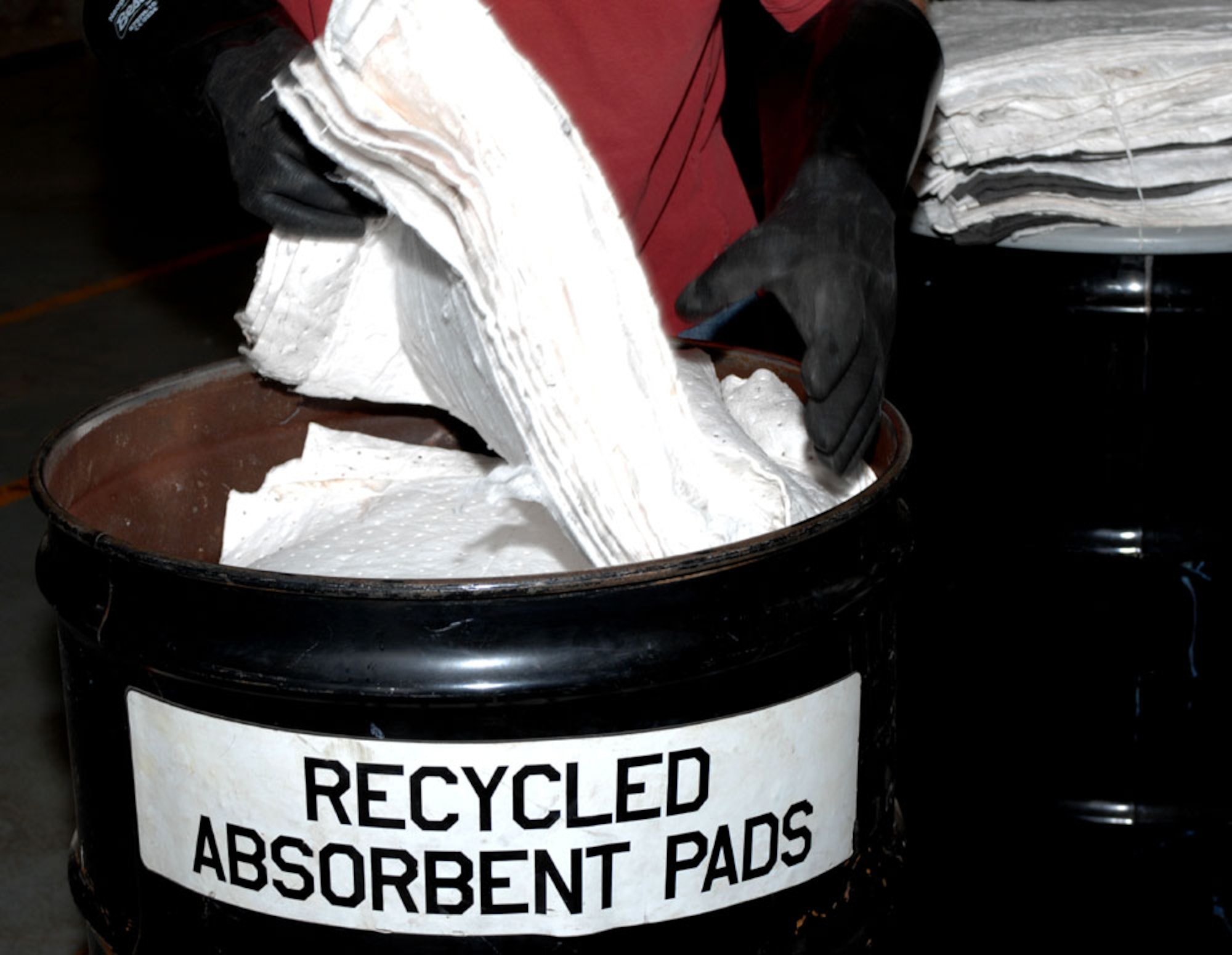 Dyess AFB, Texas - Cleaned absorbent pad are place in a drum to be transported to the flight line. Once the pads are used they are placed in a spinning machine to spin the liquid out and then reused again. (U.S. Air Force photo by Courtney Richardson)