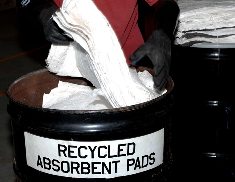 Dyess AFB, Texas - Cleaned absorbent pad are place in a drum to be transported to the flight line. Once the pads are used they are placed in a spinning machine to spin the liquid out and then reused again. (U.S. Air Force photo by Courtney Richardson)