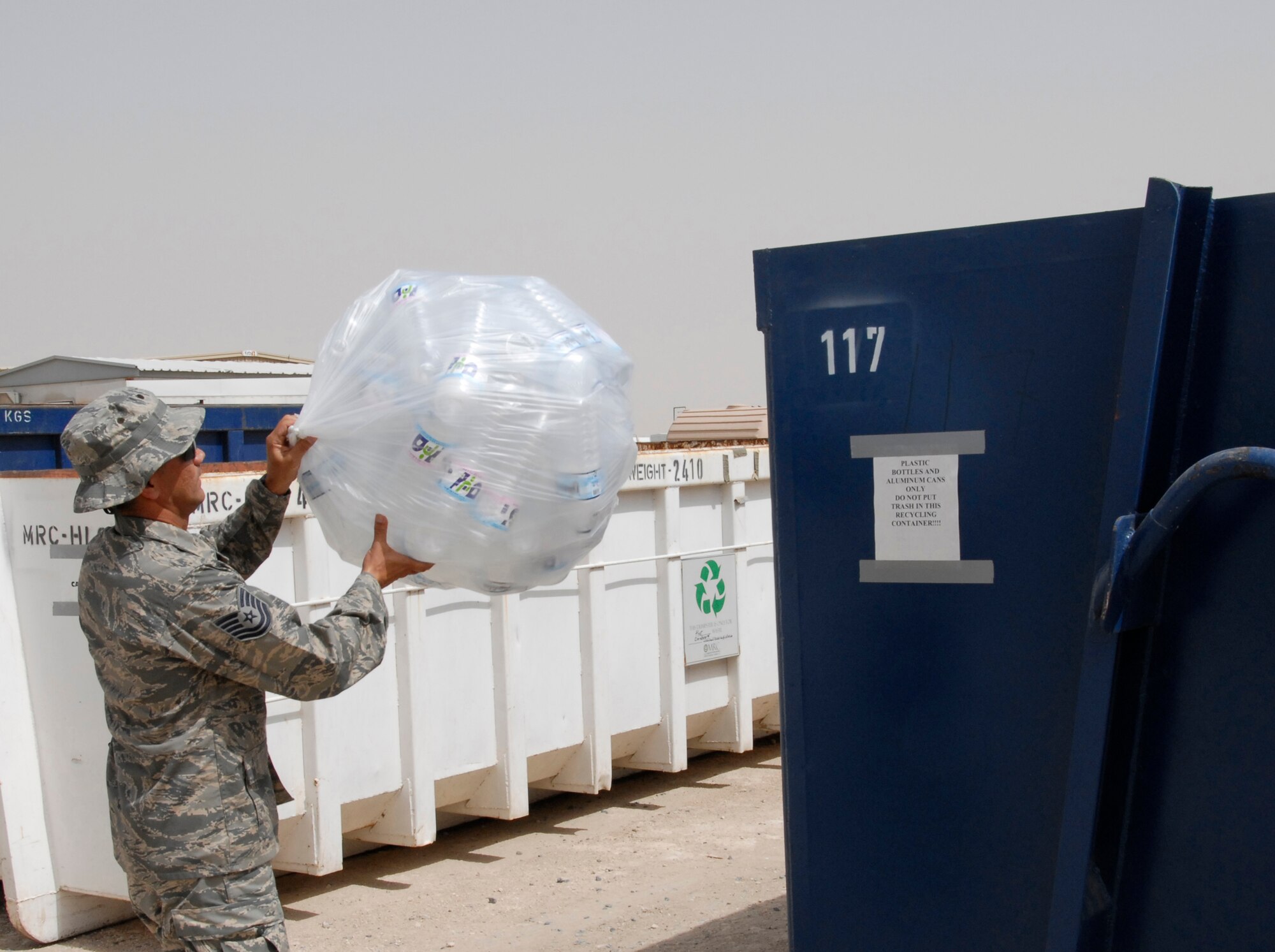 SOUTHWEST ASIA -- Technical Sgt. Hector Aponte, 386th Expeditionary Civil Engineer Squadron environmental flight, swings a bag of water bottles into the dumpster of recyclable materials container recently at an air base in Persian Gulf Region. Sergeant Aponte's duties require him to carry out programs that ensure the Airmen assigned to the 386th Air Expeditionary Wing are good stewards of the environment. (U.S. Air Force photo/Capt. Jason McCree)