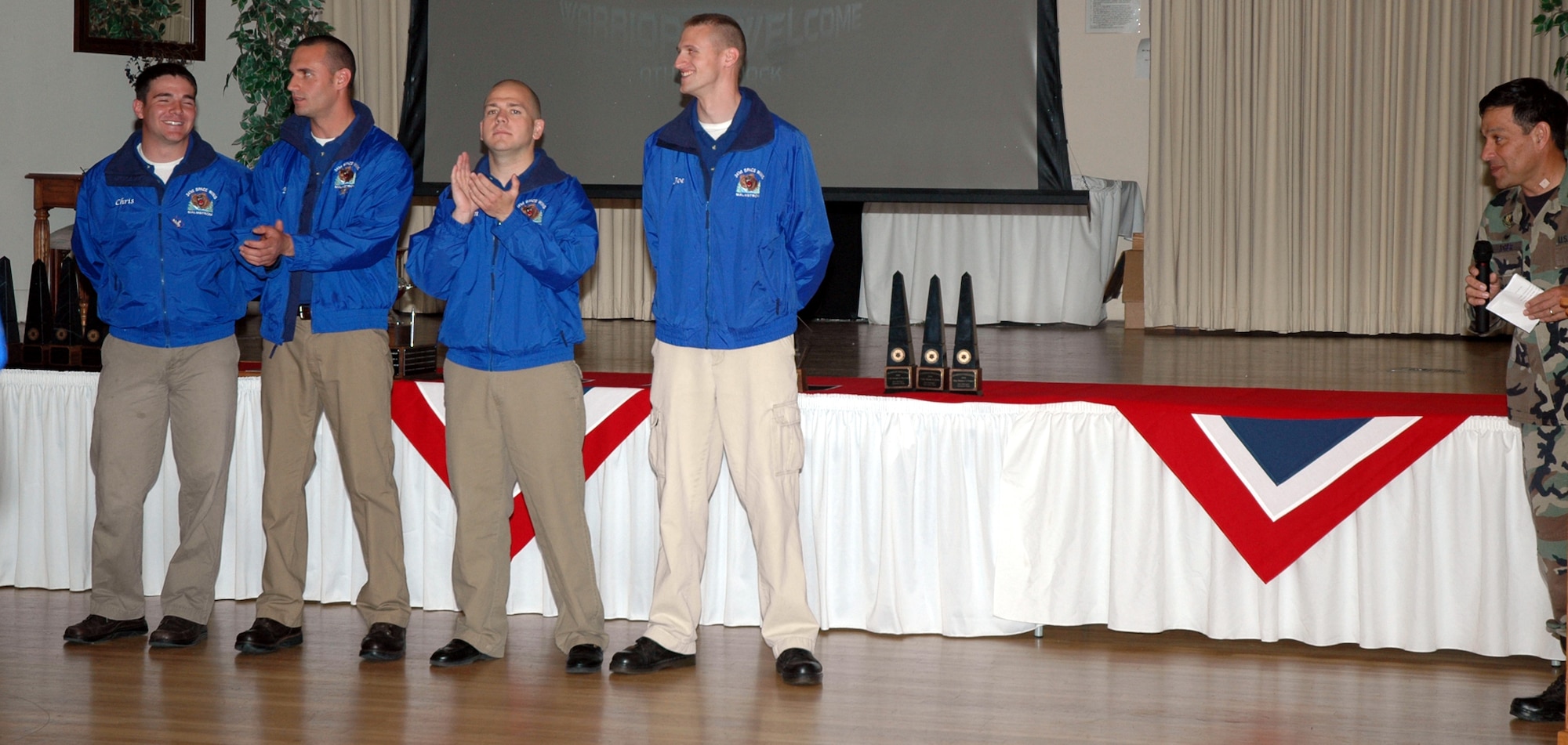 Col. Steve Asher, 341st Security Forces Group commander looks on after calling up his four-man team that earned the award for Best Security Forces Team in 20th Air Force after competing in a combat marksmanship and an endurance course. From right to left, 1st Lt. Joseph Schneider was an M-203 gunner and managed to hit all five targets during his scenario. Staff Sgt. Johnathan Van Nevel scored two confirmed kills and two more potential kills during a tactics scenario. Senior Airman Billy Briggs scored the most push-ups – 67 in one minute – following a two-mile run in the endurance course. Senior Airman Chris Stephens shot perfect with the M-9, scoring 24 targets in 57 seconds. (U.S. Air Force photo/Airman 1st Class Emerald Ralston)