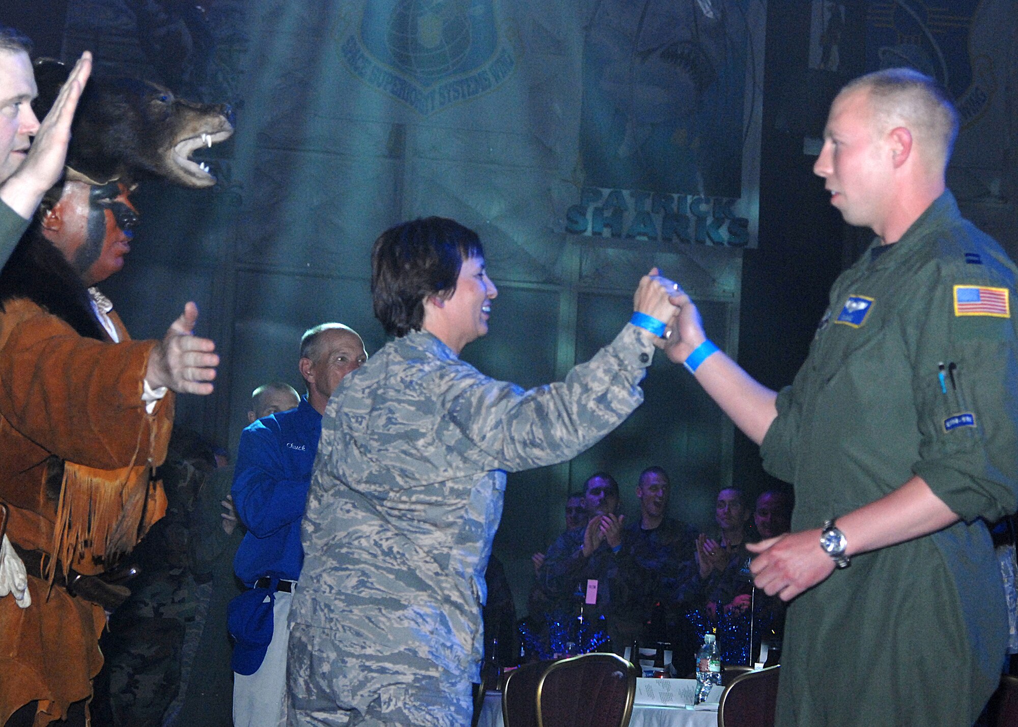 Capt. Daran Gaus, 40th Helicopter Squadron pilot, gets a high-five from 341st Space Wing Commander Col. Sandy Finan, after he and his crew were named the best helicopter operations team at the Guardian Challenge 2008 awards ceremony May 9. Lt. Col. Dave Bunz and Grizz wait to congratulate him as other members of the Guardian Challenge Team cheer in the background. (U.S. Air Force photo/Duncan Wood)