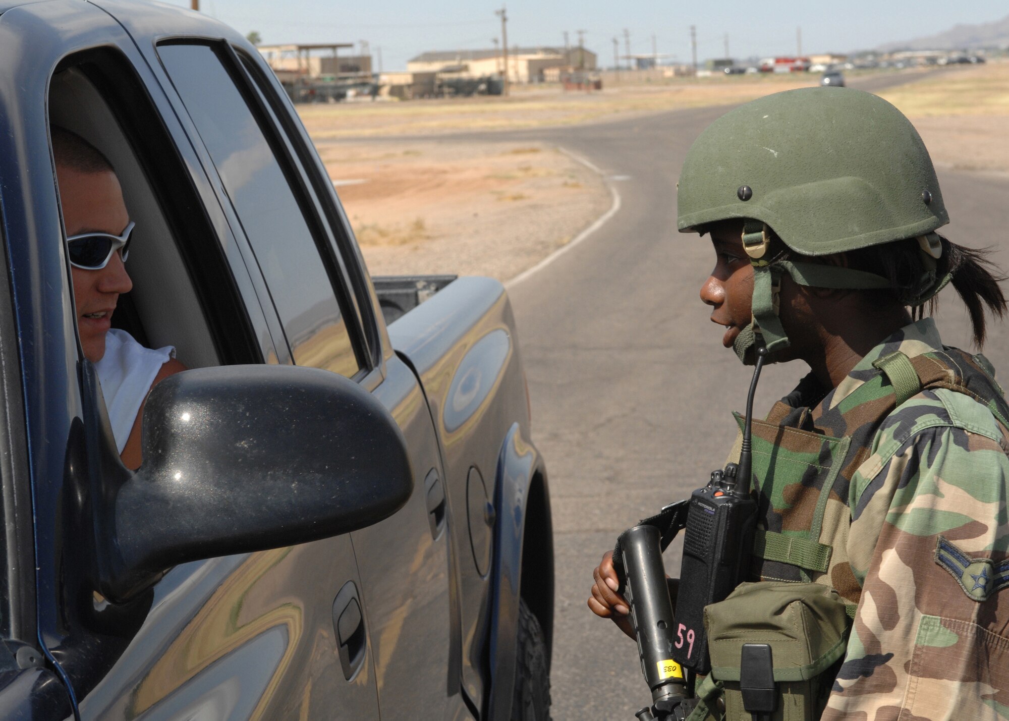 Airman First Class Ikaisha McCoy checks the identification of a driver at a Traffic Control Point (TCP) during exercise Crown Talon 08-02 at Luke Air Force Base, Ariz on May 13. Airman McCoy is a security forces apprentice with the 56th Security Forces squadron. U.S. Air Force photo by Tech. Sgt. Raheem Moore (released)    