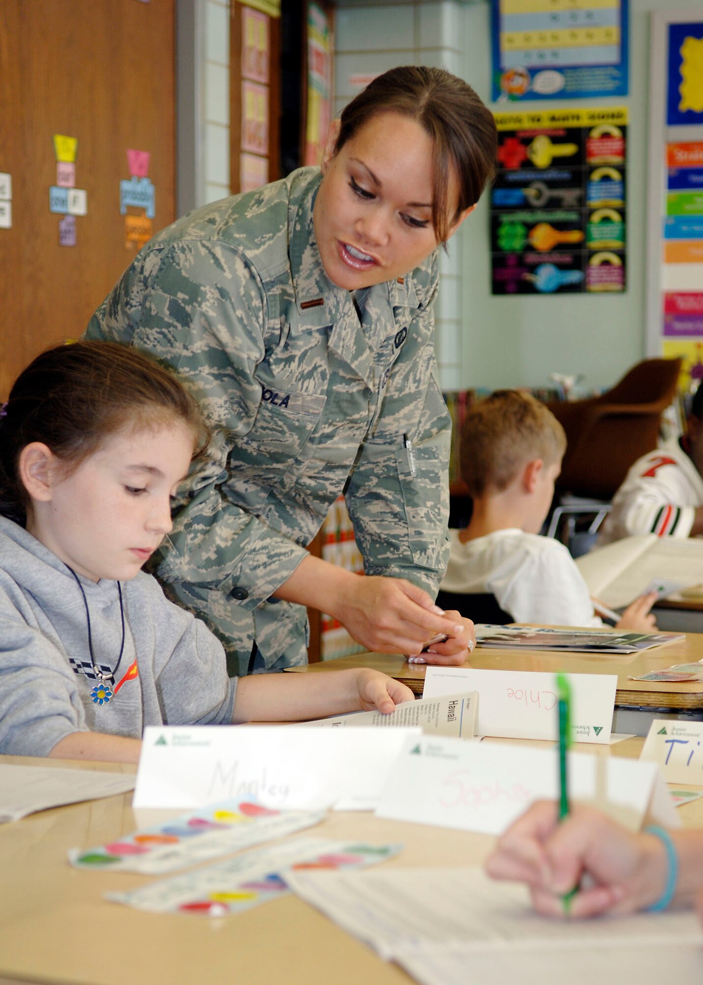 SCOTT AIR FORCE BASE, Ill. -- 2nd Lt. Elizabeth Nola, 375th Contracting Squadron, assists a student in a fourth grade class during Junior Achievement in a Day held at Douglas Elementary School in Belleville, Ill. “JA in a Day” is a special Junior Achievement delivery method that facilitates a partnership between Scott AFB members and Douglas Elementary. (U.S. Air Force photo/Tech. Sgt. Tony Tolley)