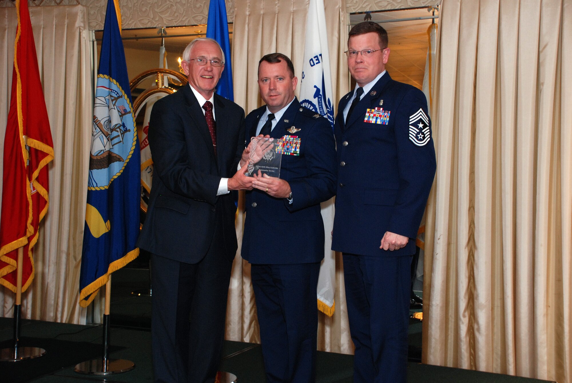 SCOTT AIR FORCE BASE -- Col. Al Hunt, 375th Airlift Wing commander, and Chief Master Sgt. Jim Suttles, 375th Airlift Wing command chief, accept the community service award from David Swanson, Greater St. Louis Federal Executive Board chair, on May 8. (Courtesy photo)