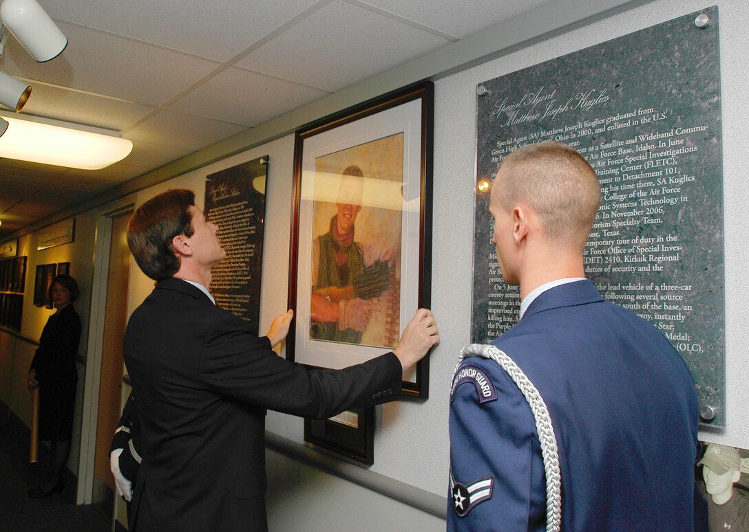 Special Agent James Spell, Deputy Director of Staff, Headquarters Air Force Office of Special Investigations, hangs the portrait of Special Agent Matthew Kulics in the AFOSI Hall of Heroes. (U.S. Air Force photo/Tech. Sgt. John Jung) 