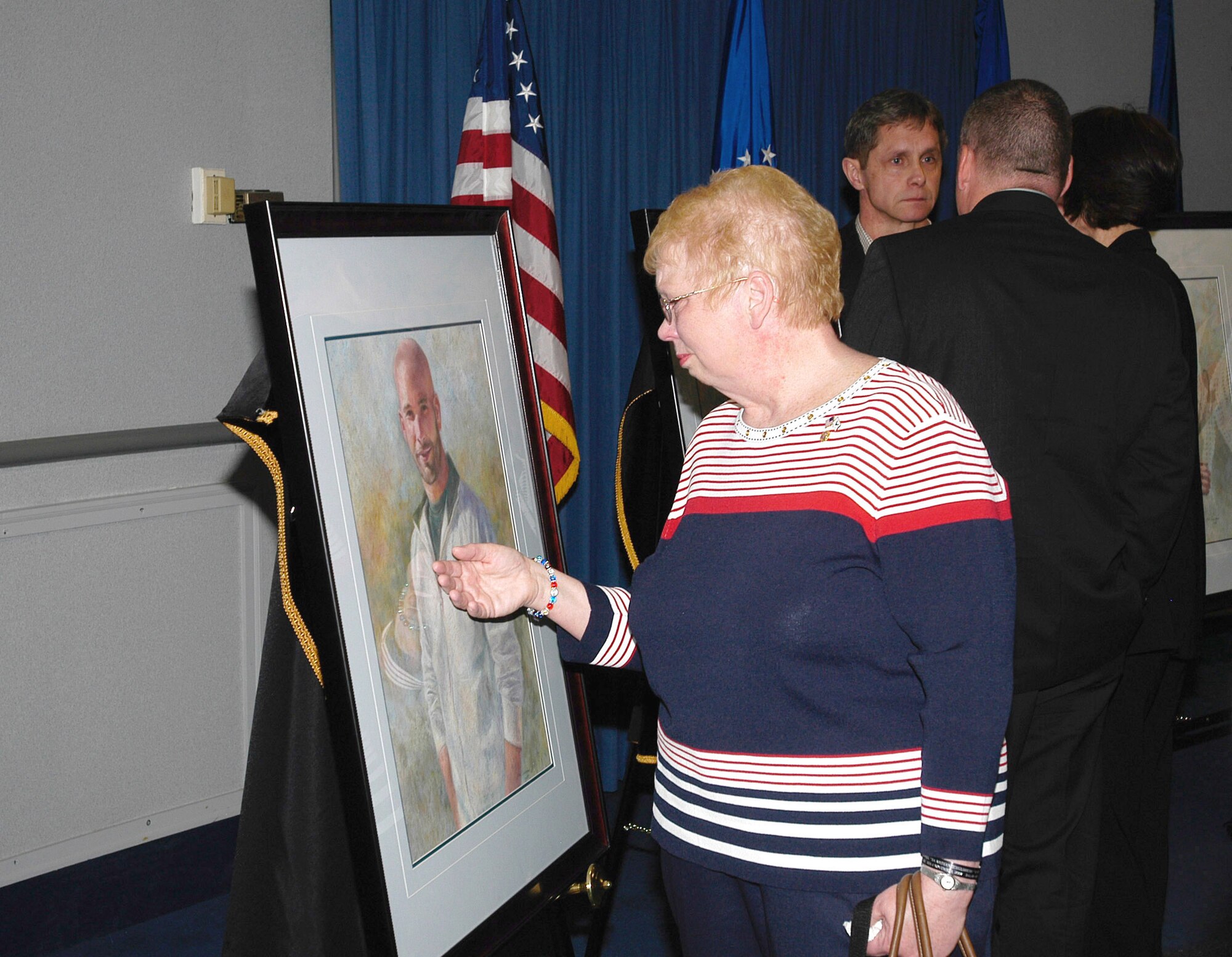 Lorraine Wieger, mother of Special Agent David Wieger, stops to touch a portrait of her son who was killed in Iraq on November 1, 2007. A portrait of SA Wieger and four other special agents were dedicated May 13 in the Headquarters Building, Air Force Office of Special Investigations Hall of Heroes. Agent Wieger was killed when his vehicle was struck by an improvised explosive device. Special Agent Wieger was posthumously awarded the Bronze Star, Purple Heart, Air Force Commendation Medal and the Air Force Combat Action Medal. (U.S. Air Force photo/Tech. Sgt. John Jung)
