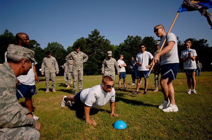 Brandon Jones does push-ups while Airmen from security forces cheer him on during the "Guns N' Hoses" fitness challenge at the Charleston AFB picnic grounds May 12. Jones is with the 437 SFS. (U.S. Air Force photo/Senior Airman Nicholas Pilch)