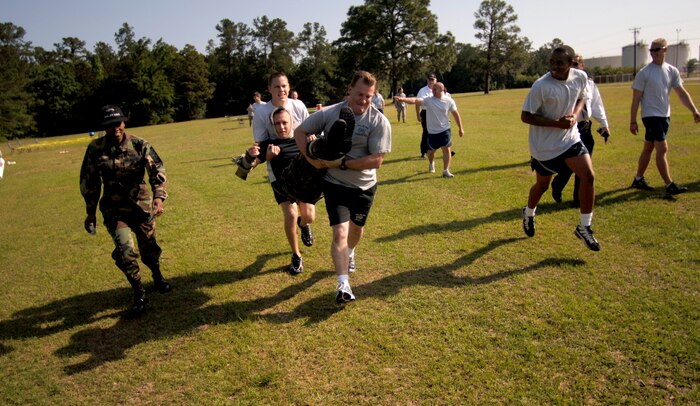 Christopher Mills and Eric Church carry Stephen Thompson during the "Guns N' Hoses" fitness challenge at the Charleston AFB picnic grounds May 12. Mills, Church and Thompson are with the 437 CES fire department. (U.S. Air Force photo/Senior Airman Nicholas Pilch) 