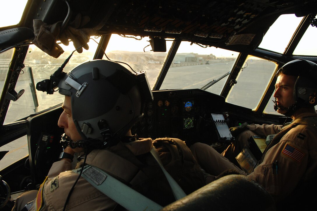 BALAD AIR BASE, Iraq -- Col. Donald Kimminau, 332nd Expeditionary Operations Group deputy commander, and Capt. Jesse Caldwell, 777th Expeditionary Airlift Squadron aircraft commander, look on as cargo is brought up to the aircraft for loading in Southwest Asia, May 7. The 777 EAS personnel estimate they have prevented approximately 10,000 convoy vehicles and about 27,000 servicemembers from traveling along improvised explosive device laden Iraqi roads since the squadron stood up in January 2006. This was accomplished by providing air transport via C-130 aircraft, the 'work horse' of the Air Force fleet. Colonel Kimminau is deployed from Maxwell Air Force Base, Ala., and Captain Caldwell is deployed from Little Rock Air Force Base, Ark. (U.S. Air Force photo/ Senior Airman Julianne Showalter)
