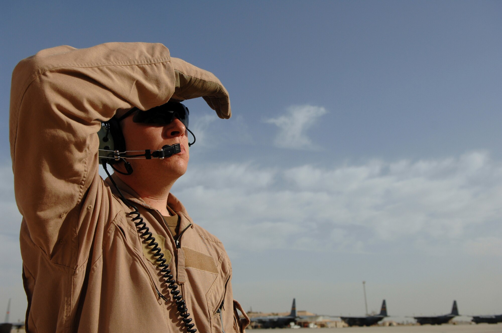 BALAD AIR BASE, Iraq -- Airman 1st Class Nicholas Ellwood, 777th Expeditionary Airlift Squadron loadmaster, communicates with pilots in the cockpit during start up before a combat mission here, May 7. The 777 EAS personnel estimate they have prevented approximately 10,000 convoy vehicles and about 27,000 servicemembers from traveling along improvised explosive device laden Iraqi roads since the squadron stood up in January 2006. This was accomplished by providing air transport via C-130 aircraft, the 'work horse' of the Air Force fleet. Airman Ellwood is deployed from Little Rock Air Force Base, Ark. (U.S. Air Force photo/ Senior Airman Julianne Showalter)