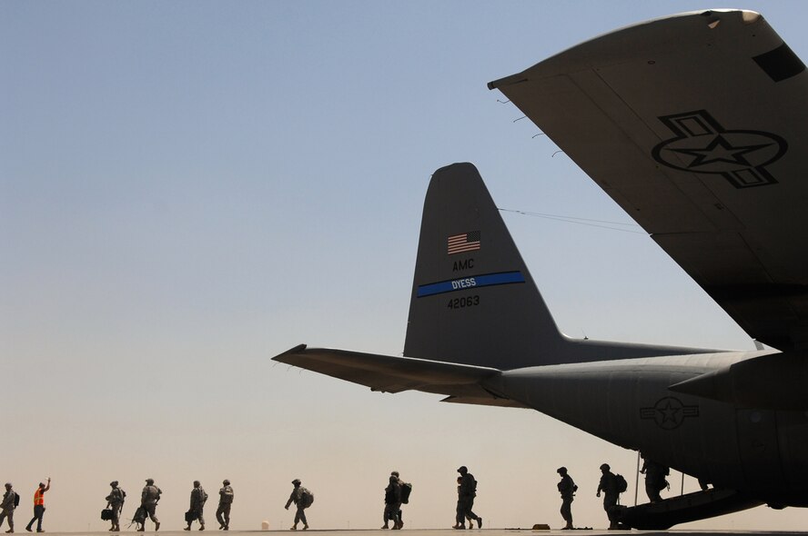 BALAD AIR BASE, Iraq -- Servicemembers exit a C-130 Hercules here, May 10. The 777th Expeditionary Airlift Squadron personnel estimate they have prevented approximately 10,000 convoy vehicles and about 27,000 servicemembers from traveling along improvised explosive device laden Iraqi roads since the squadron stood up in January 2006. This was accomplished by providing air transport via C-130 aircraft, the 'work horse' of the Air Force fleet. (U.S. Air Force photo/ Senior Airman Julianne Showalter)