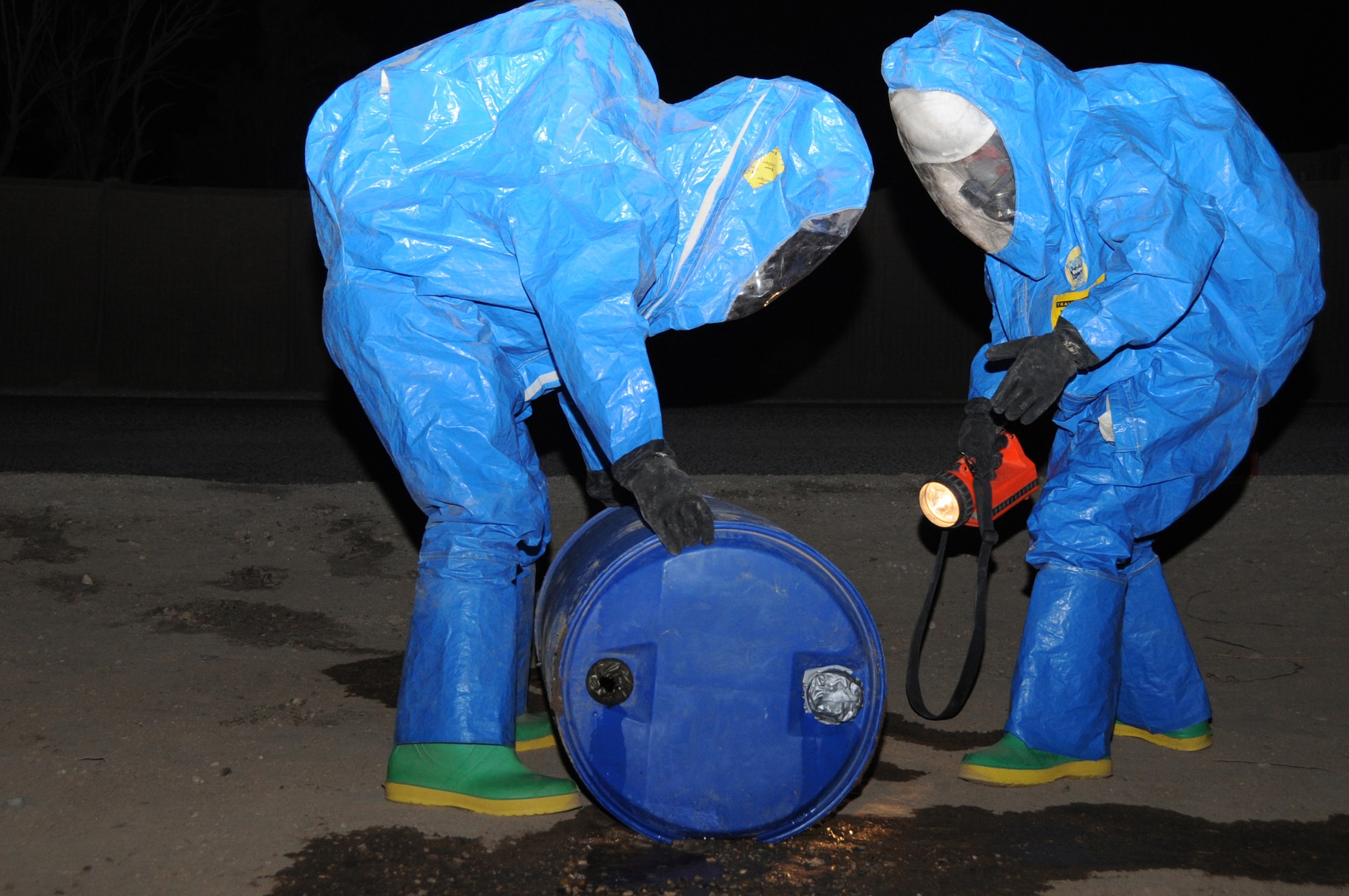 ALI BASE, Iraq -- Staff Sgt. Daryl Brannan and Senior Airman John Foxx, 407th Expeditionary Civil Engineering Squadron firefighters, assess a simulated chemical spill in their Level A Hazmat suits during a recent exercise here May 13.  Air Force Airmen train together with Army Soldiers to share essential skills and knowledge in the case of an incident on Contingency Operating Base Adder and Ali Base.    Sergeant Brannan and Airman Foxx are deployed from Mountain Home AFB, Idaho.  (U. S. Air Force photo / Tech. Sgt. Sabrina Johnson)