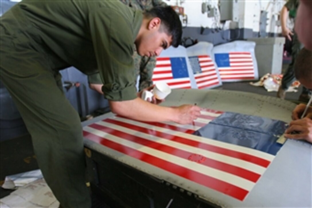 U.S. Marine Corps Lance Cpl. Michael Cruz, with Marine Medium Helicopter Squadron 265, 31st Marine Expeditionary Unit, applies touch-ups to an American flag on the panel of a CH-46E Sea Stallion helicopter aboard the USS Essex (LHD 2) on May 11, 2008.  The Essex Expeditionary Strike Group is underway off the coast of Burma for potential humanitarian assistance operations in the wake of Cyclone Nargis.  