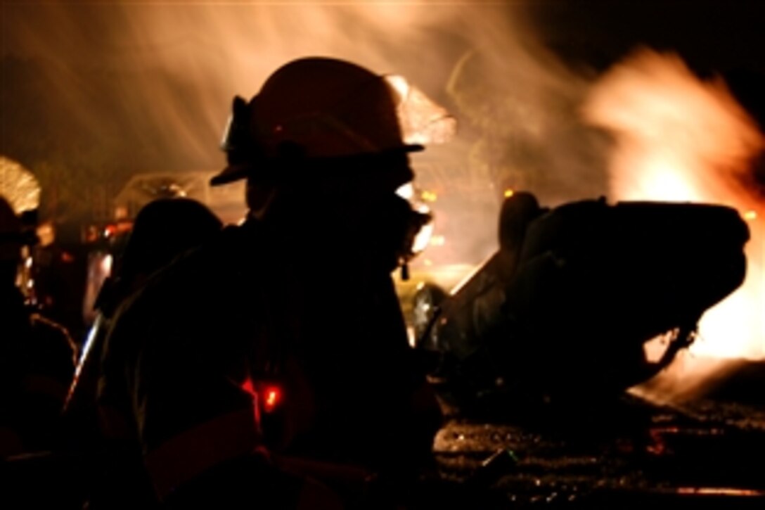 The Marine Corps Base Japan Fire Department and emergency medical technicians work quickly to remove simulated victims from overturned vehicles while simultaneously putting out fires before they could enter the building to save any survivors during Constant Vigilance 2008 on Camp Foster, Okinawa, Japan, May 6, 2008.
