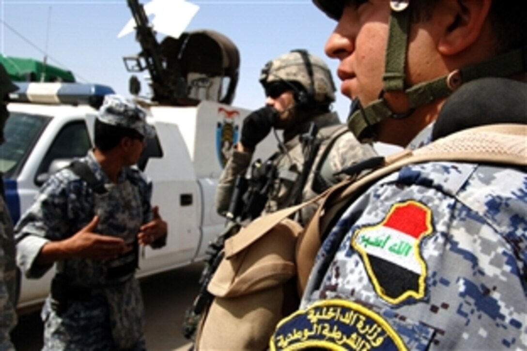 U.S. Army Staff Sgt. David Snow speaks to an Iraqi National Police shift leader at a traffic checkpoint near Forward Operating Base Loyalty in Southern Baghdad, May 11, 2008, while his unit patrols around the base. Snow is assigned to the 10th Mountain Division's Military Police Platoon, Headquarters Company, Brigade Special Troops Battalion, 4th Brigade Combat Team.