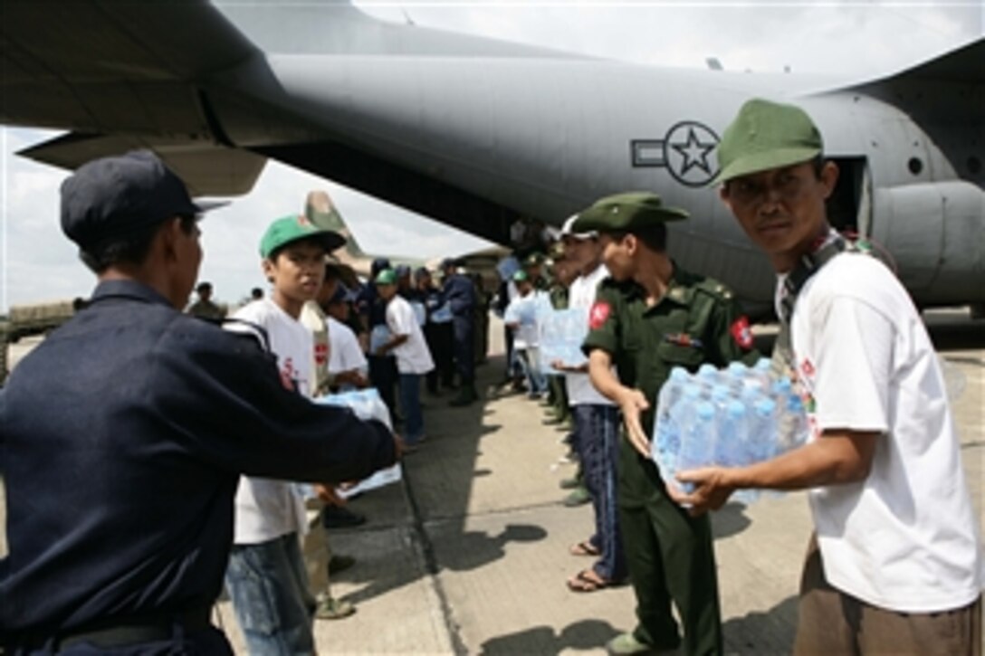 Civilians and Burmese service members form a line to unload water supplies from a U.S. Air Force C-130 Hercules aircraft at Rangoon International Airport in Burma on May 12, 2008.  The shipment of water, mosquito nets and blankets arrived on the first of three planned relief flights to provide aid to citizens devastated by Tropical Cyclone Nargis.  
