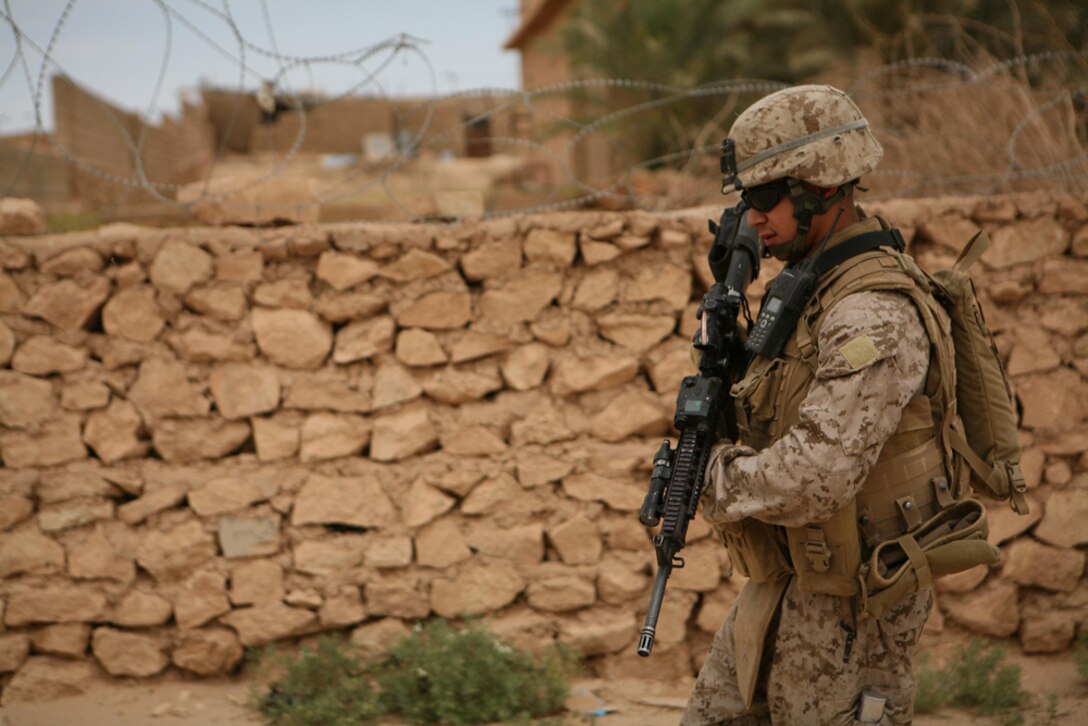 Corporal Roland L. Ramirez, 22, a team leader with Company K, 3rd Battalion, 4th Marine Regiment, Regimental Combat Team 5, from Mission, Texas, patrols through the city of Bani Dahir, Iraq, during a census patrol in the city. Marines with Company K conducted the patrol to find out what the community thinks about Marines and Iraqi Police. Marines were pleased to find out that the local populaceâ??s confidence in the IP is growing.