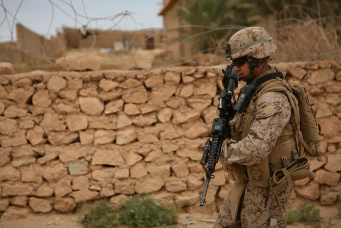 Corporal Roland L. Ramirez, 22, a team leader with Company K, 3rd Battalion, 4th Marine Regiment, Regimental Combat Team 5, from Mission, Texas, patrols through the city of Bani Dahir, Iraq, during a census patrol in the city. Marines with Company K conducted the patrol to find out what the community thinks about Marines and Iraqi Police. Marines were pleased to find out that the local populaceâ??s confidence in the IP is growing.
