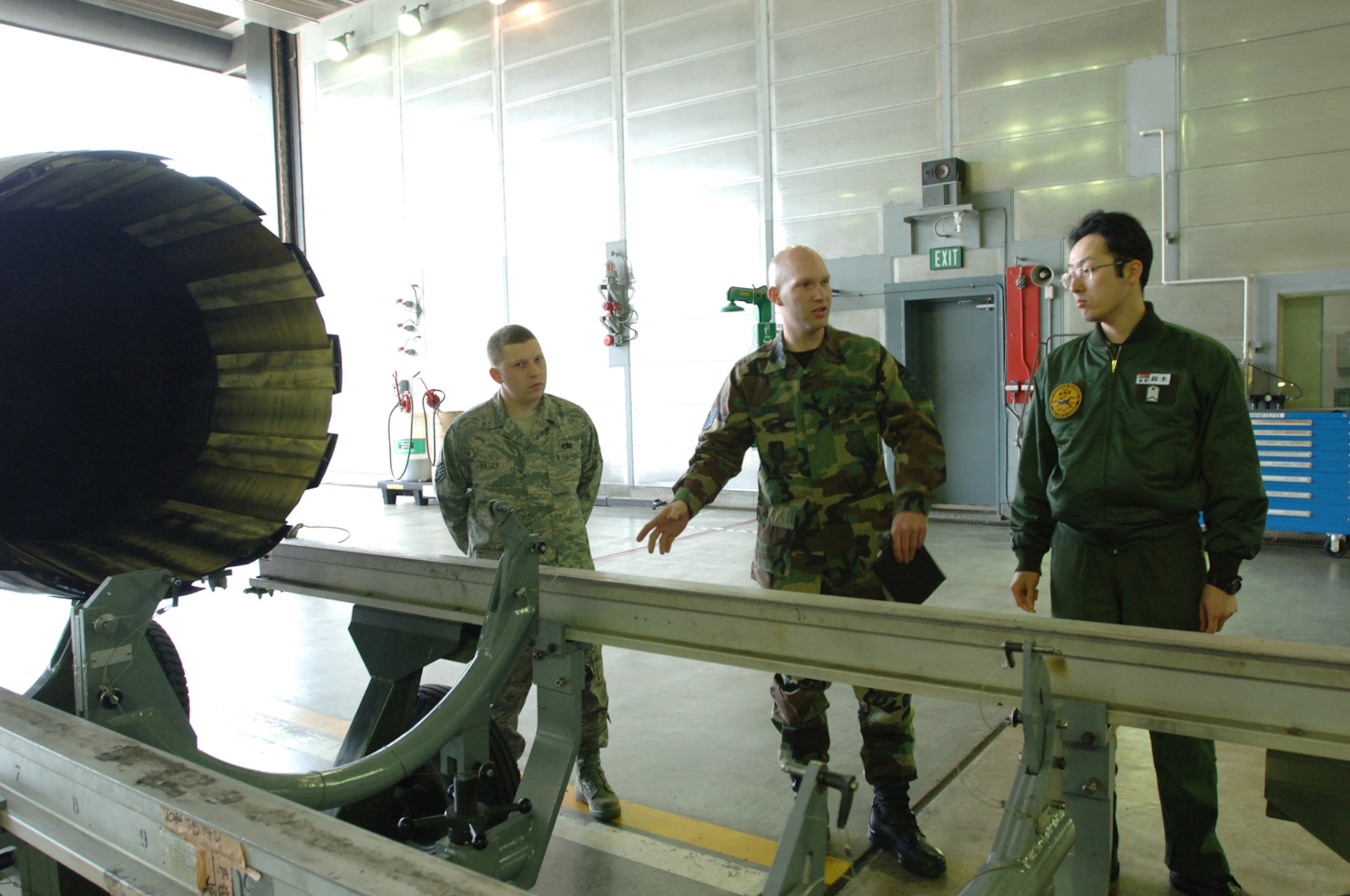 MISAWA AIR BASE, Japan -- Staff Sgt. Joseph Bilger (left), 35th propulsion flight jet engine mechanic, and Tech. Sgt. Marcus Sydow (center), 35th propulsion shop non-powered age NCOIC, introduce Japanese Air Self Defense Force Staff Sgt. Masanobu Suzuki (right), to some of their equipment on the flightline on May 15, 2008. The purpose of this bilateral exchange is to build friendships and learn the differences between both forces within the same job. (U.S. Air Force photo by Senior Airman Robert Barnett)
