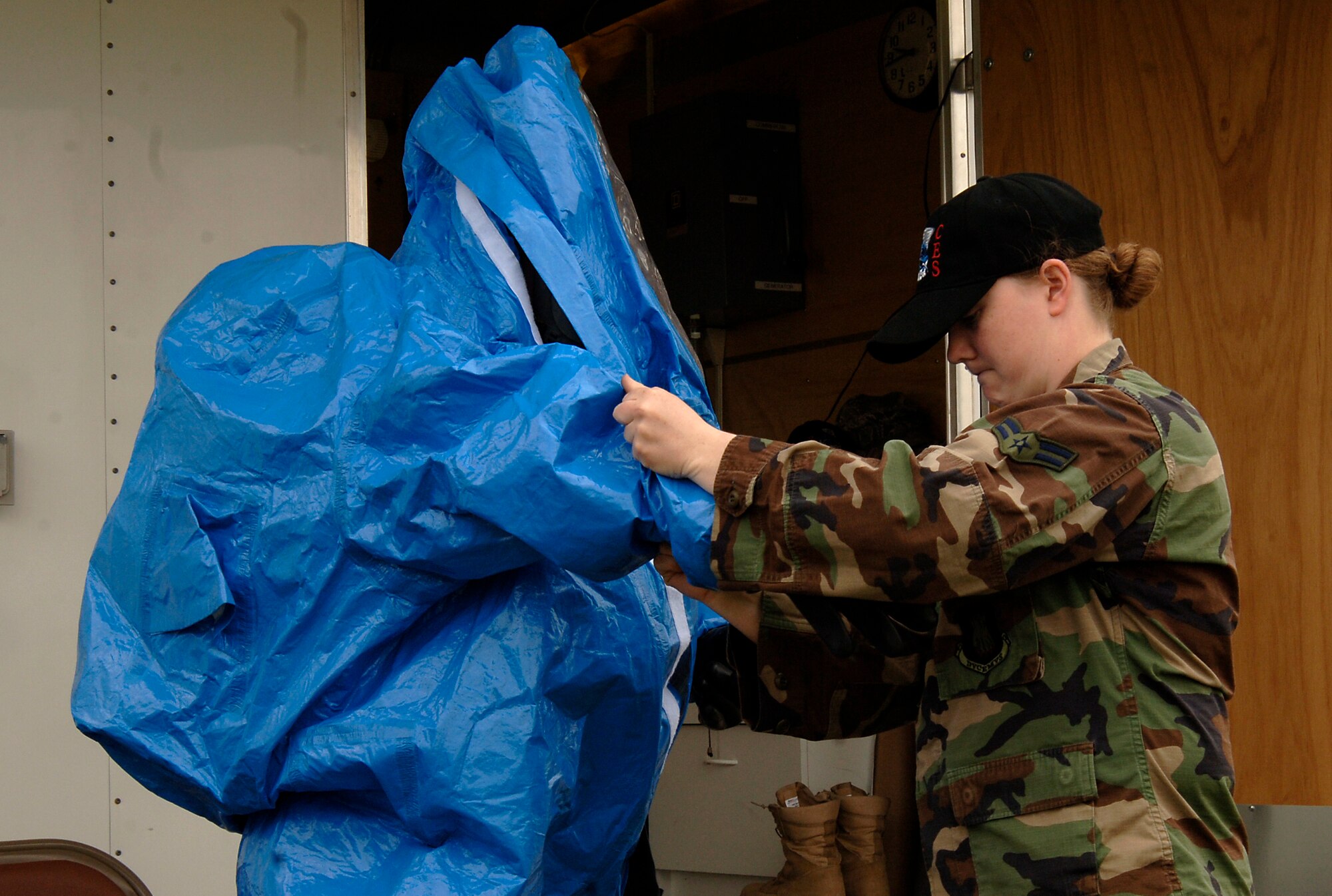 MCCONNELL AIR FORCE BASE, Kan. -- Airman 1st Class Carrie Gay, 22nd Civil Engineering Squadron, assists Tech.  Sgt. Shawn Leach, 22nd Civil Engineering Squadron, into a Level A suit during a simulated chemical attack, May 13. The Level A suit, provides the highest form of protection against all manner of contaminants. (Photo by Airman Justin Shelton)
