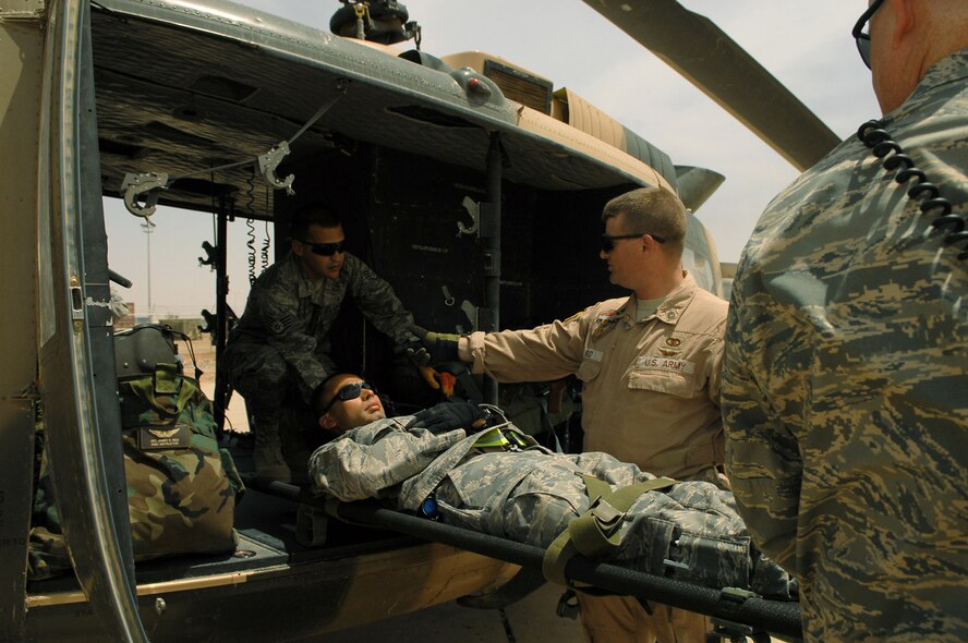 Army Sgt. 1st Class James Reid shows Airmen from the 332nd Expeditionary Medical Group the proper way to secure a trauma patient into an Iraqi air force Huey II May 14 at Balad Air Base, Iraq. The training took place just before the first Iraqi air force medical evacuation mission was flown from the Air Force Theater Hospital to the U.S. Army's 86th Combat Support Hospital in Baghdad. Sergeant Reid is a Coalition Air Forces Transition Team - Air Force Training School instructor. (U.S. Air Force photo/Senior Airman Julianne Showalter) 