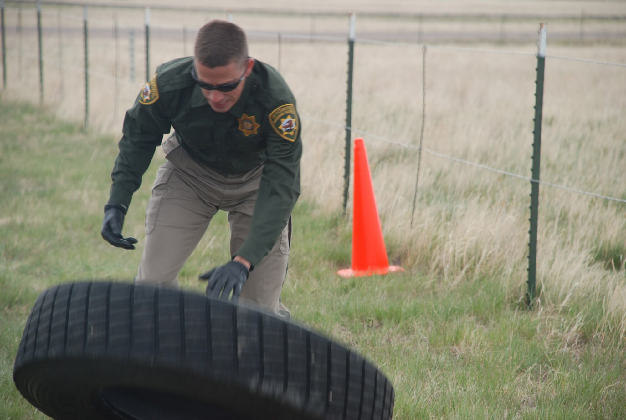 Officer Kelly Broad, Wyoming Highway Patrol, flips a tire Wednesday during the obstacle course portion of the competition.