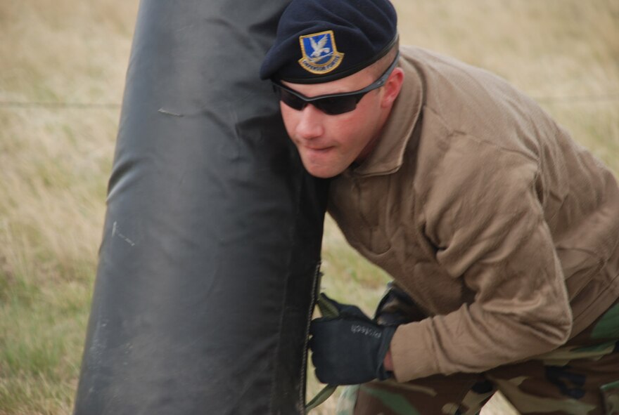 Senior Airman Rusty Haumesser, 90th Security Forces Squadron, pushes a tackle sled during the obstacle portion of the National Police Week competition near the Peacekeeper Highbay Wednesday. The competition challenged police teams from many different local law enforcement departments. For more information see Page 12 (Photos by Airman 1st Class Alex Martinez).