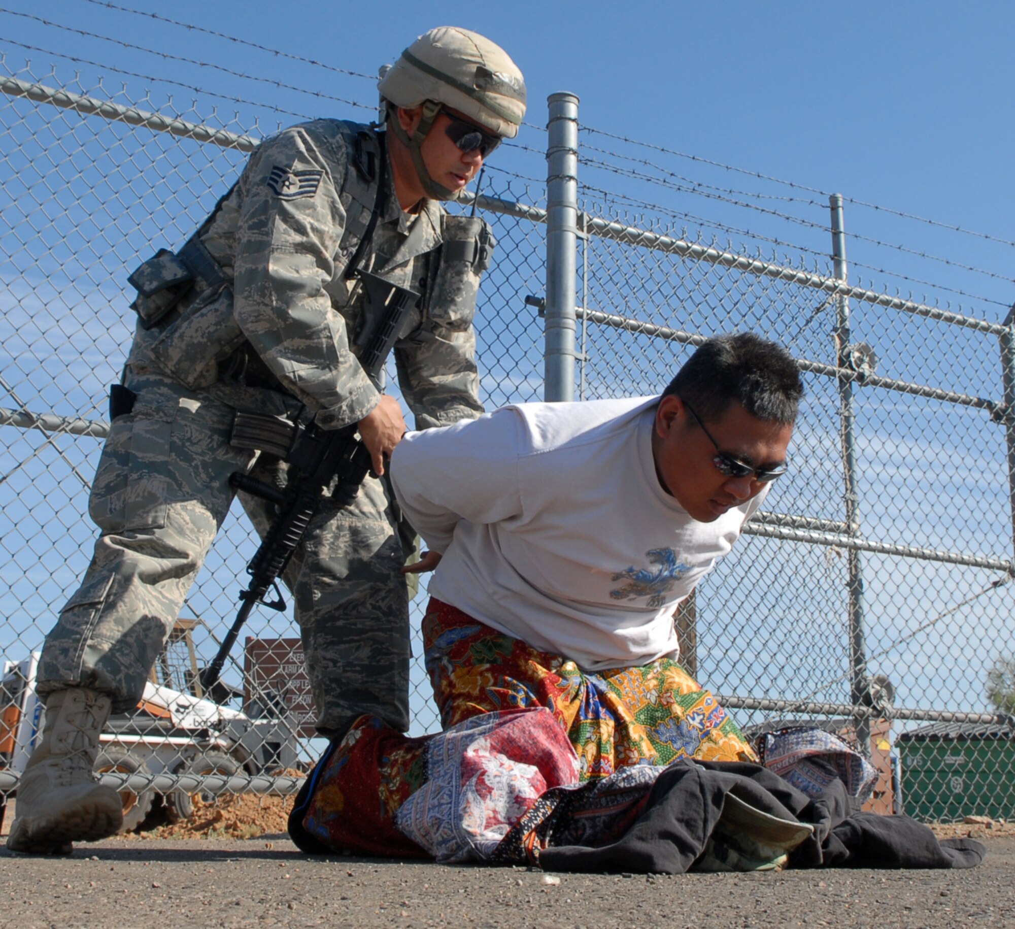 Staff Sergeant Markus Mindoro simulates the apprehension of a civilian near the entry control point during exercise Crown Talon 08-02, May 14, Luke Air Force Base, Ariz. Sergeant Mindoro is combat arms instructor for the 56th Security Forces Squadron. (U.S. Air Force photo/Staff Sergeant Jerry Fleshman)