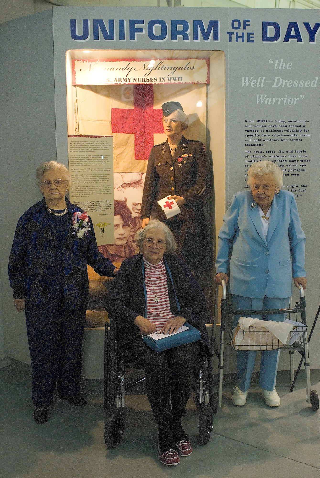 (Left to right) Dorothy Lewis, Grace McDonnell, and Mae Bowen pose for a photo in front of the dress uniform and bronze star Mrs. Lewis donated to the Air Mobility Command Museum May 9. These combat nurses are the only three out of 18 Normandy Nightingales alive today. (U.S. Air Force photo/Roland Balik)