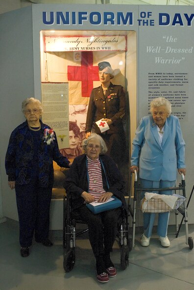 (Left to right) Dorothy Lewis, Grace McDonnell, and Mae Bowen pose for a photo in front of the dress uniform and bronze star Mrs. Lewis donated to the Air Mobility Command Museum May 9. These combat nurses are the only three out of 18 Normandy Nightingales alive today. (U.S. Air Force photo/Roland Balik)