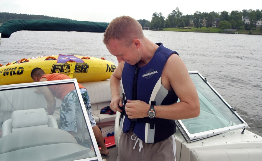Capt. Jason Knab fastens on a life vest before boating on Lake Tobesofkee last summer as a reminder to practice commonsense safety tips when participating in water activities. 