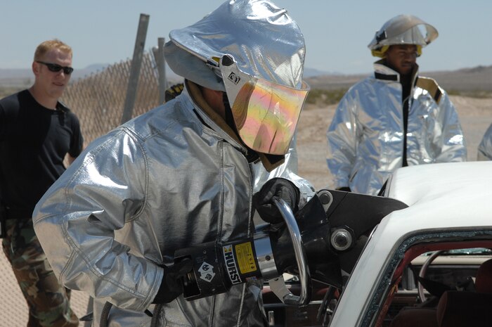 NELLIS AIR FORCE BASE, Nev.—A firefighter from the 99th Civil Engineer Squadron uses Hurst shears to cut off the top of a car during an auto extrication training class here May 8. Nellis firefighters conduct training every shift to prepare them for potential scenarios they may face on the job such as confined-space rescue and rescuing victims from burning vehicles. The type of training they receive changes daily to keep their skills sharp. (U.S. Air Force photo/Senior Airman Kasabyan D. Musal)