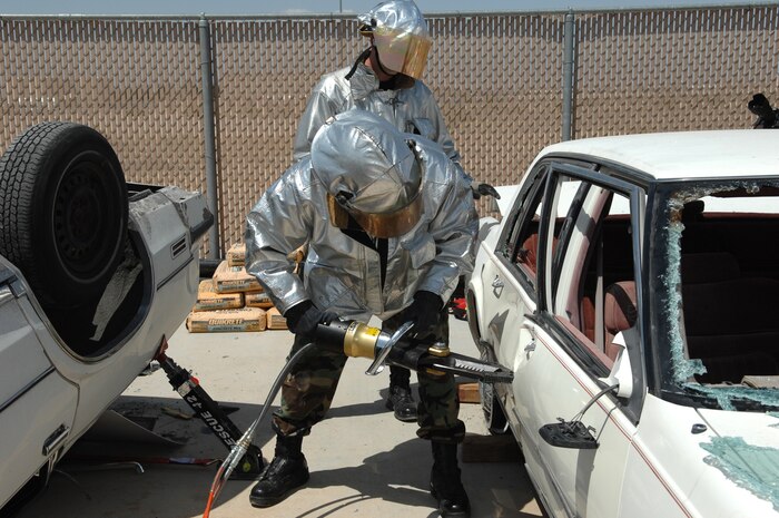 NELLIS AIR FORCE BASE, Nev.—A firefighter from the 99th Civil Engineer Squadron works to open a car door during an auto extrication training class here May 8. Nellis firefighters conduct training every shift to prepare them for potential scenarios they may face on the job such as confined-space rescue and rescuing victims from burning vehicles. (U.S. Air Force photo/Senior Airman Kasabyan D. Musal)
