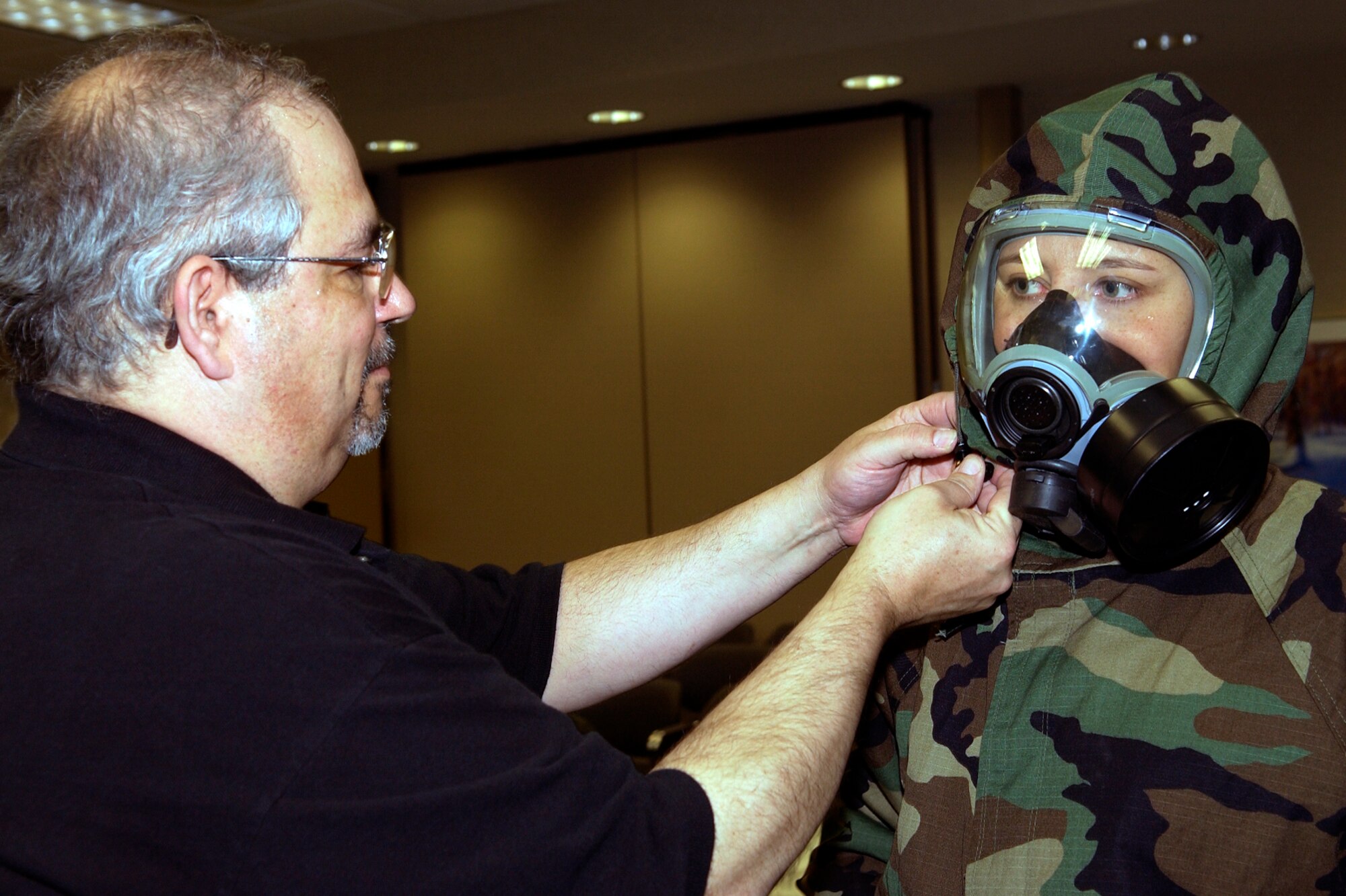 GRISSOM AIR RESERVE BASE, Ind., -- Robert Wydock, a 434th Civil Engineers Squadron readiness technician, helps adjust the hood of Lily Karas, a case manager for Congressman Joe Donnelly, during a recent outreach visit to the base. Congressional staffers and representatives visited the base, met and had lunch with senior leadership, and got a hands-on lesson in military chemical, biological, radiation and nuclear protection training. (U.S. Air Force photo/Tech. Sgt. Doug Hays)