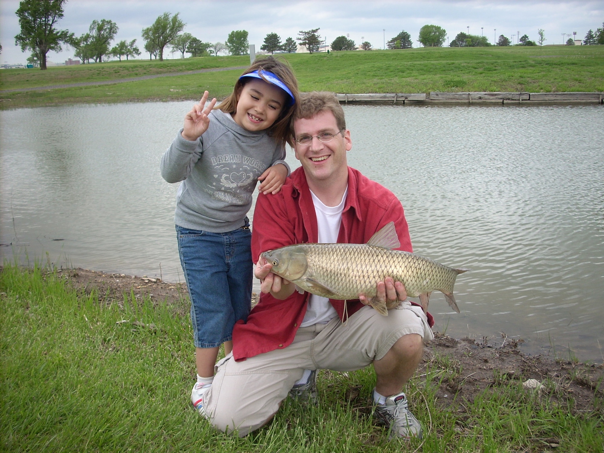 MCCONNELL AIR FORCE BASE, Kan. -- Tech. Sgt. Mike Webster, 349th Air Refueling Squadron, boom operator, holds a fish with his daughter Caren, 6, at the annual Fishing Derby held at Twin Lakes golf course, May 10.  “It felt like a hundred pounds, reeling in,” said Sergeant Webster. (Courtesy Photo)

