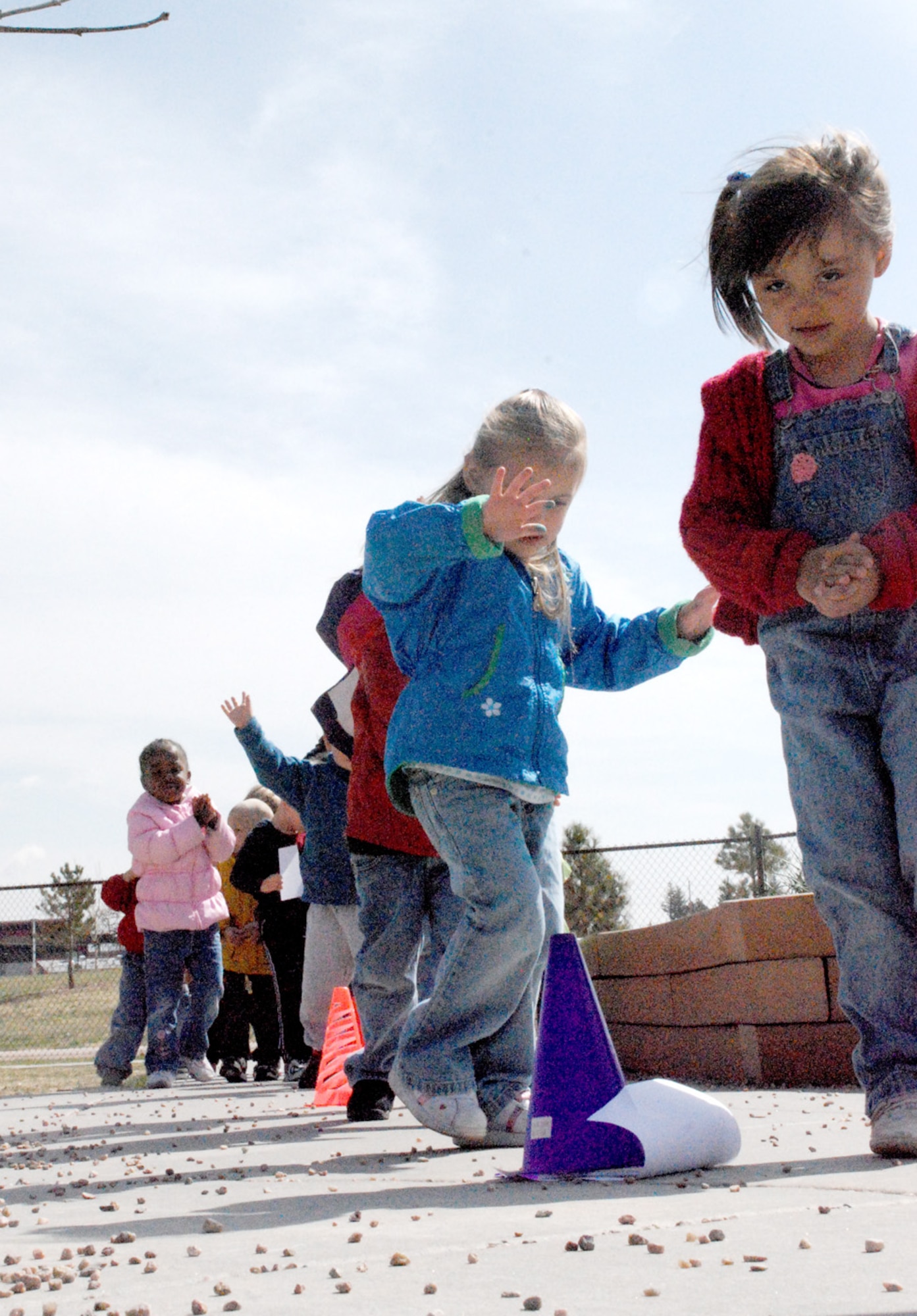 Children participate in the sneaky snake station at the Warren Child Development Center May 9. The sneaky snake part of the event required the children to form a line and move between cones alternating stretching as tall as they could and crouching.
