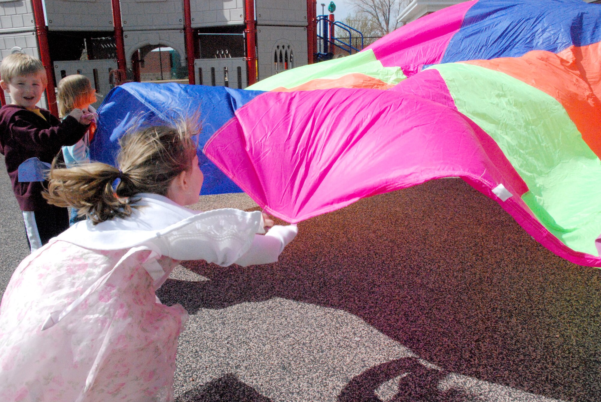 Children move a parachute up and down May 9 as part of May Fitness Month. A fitness challenge took place at the Warren Child Development Center. During the event, there were four stations in place for the children to experience: aerobics and situps; sneaky snake; paper ball throwing; and a parachute liftoff. Each station had a stamp that the children had to collect on their ticket. After all the stamps were collected, the children returned inside to receive a talk about fitness and gifts (Photos by Airman 1st Class Daryl Knee).