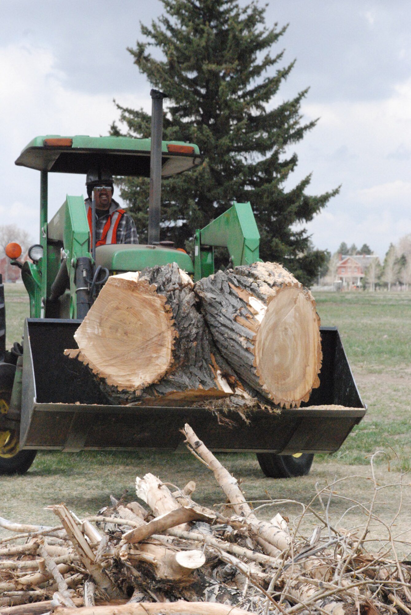Joe Munoz, Skils’Kin employee, moves part of a tree to a nearby truck at the Argonne Parade Field Wednesday. The tree was cut down for safety reasons due to instability in the trunk and bug damage (Photo by Airman 1st Class Daryl Knee).