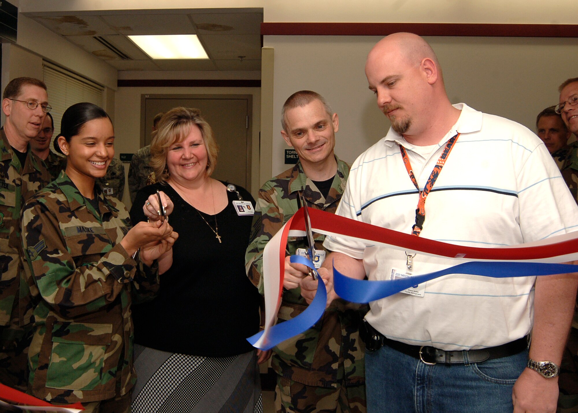 MCCONNELL AIR FORCE BASE, Kan. -- Airman 1st Class Theresa Maske, Diana Diaz, Master Sgt. Melvin Mulder and Shawn Hinkle, 22nd Medical Support Squadron, cut a ribbon for the opening of the new Tricare Operations and Patient Administration section, May 5. During the same ribbon cutting event, the opening for the new bioenvironmental section was also celebrated. (Photo by Airman 1st Class Maria Ruiz)