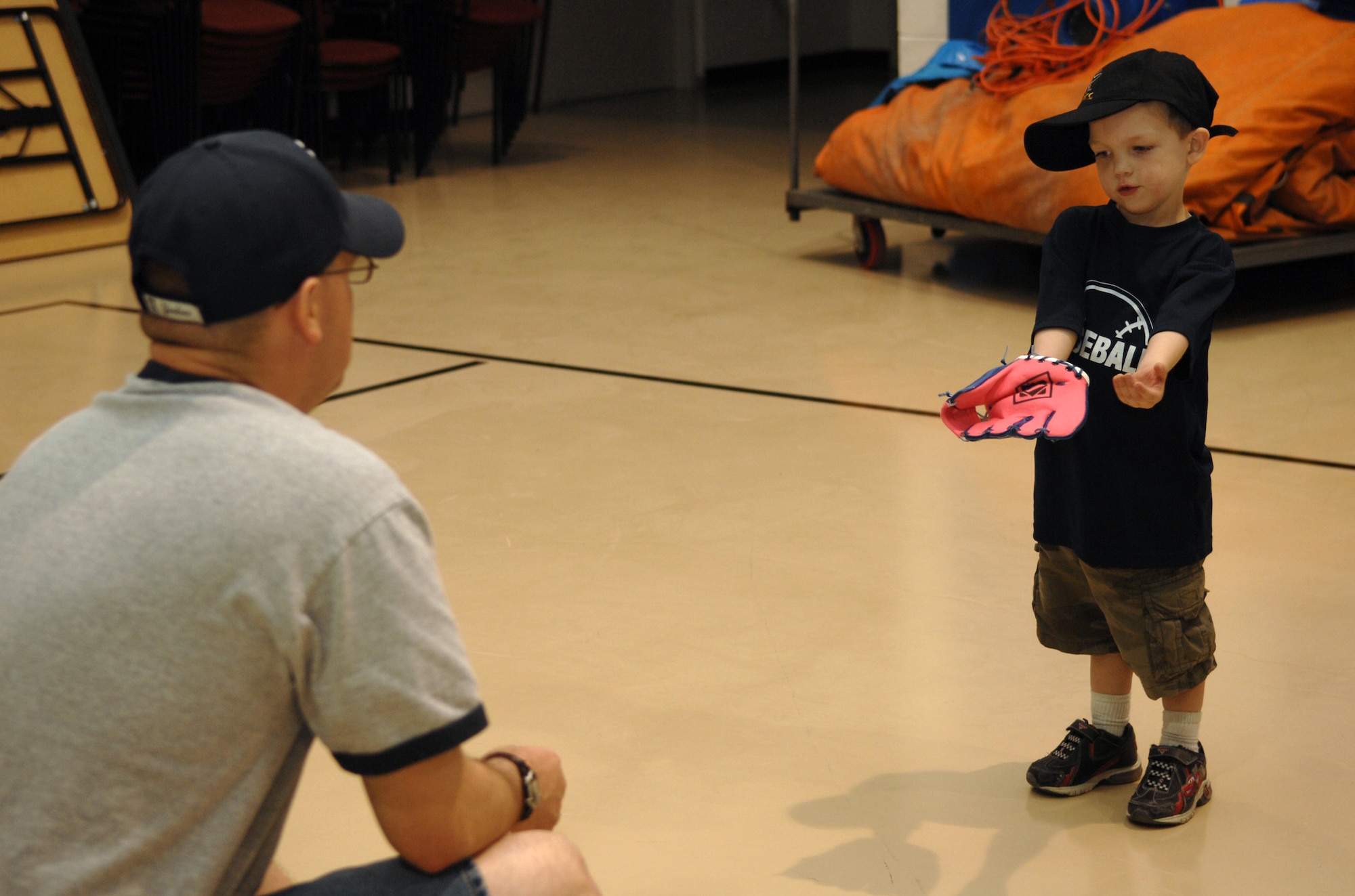 HOLLOMAN AIR FORCE BASE, N.M. -- Tech. Sgt. John Talbot, 49th Maintenance Squadron, throws a ball for his son, Steven, 4, to catch at the Youth and Teen Center at Holloman Air Force Base, N.M., May 8. They are participating in the Start Smart baseball program, which teaches children ages 3 to 5 the fundamentals of baseball before they join an official baseball team. The classes last one hour and are held twice a week for three weeks. All children are accompanied by their parents, who work with them at different stations such as throwing, catching and hitting the ball. (U.S. Air Force photo/Airman Sondra M. Wieseler)