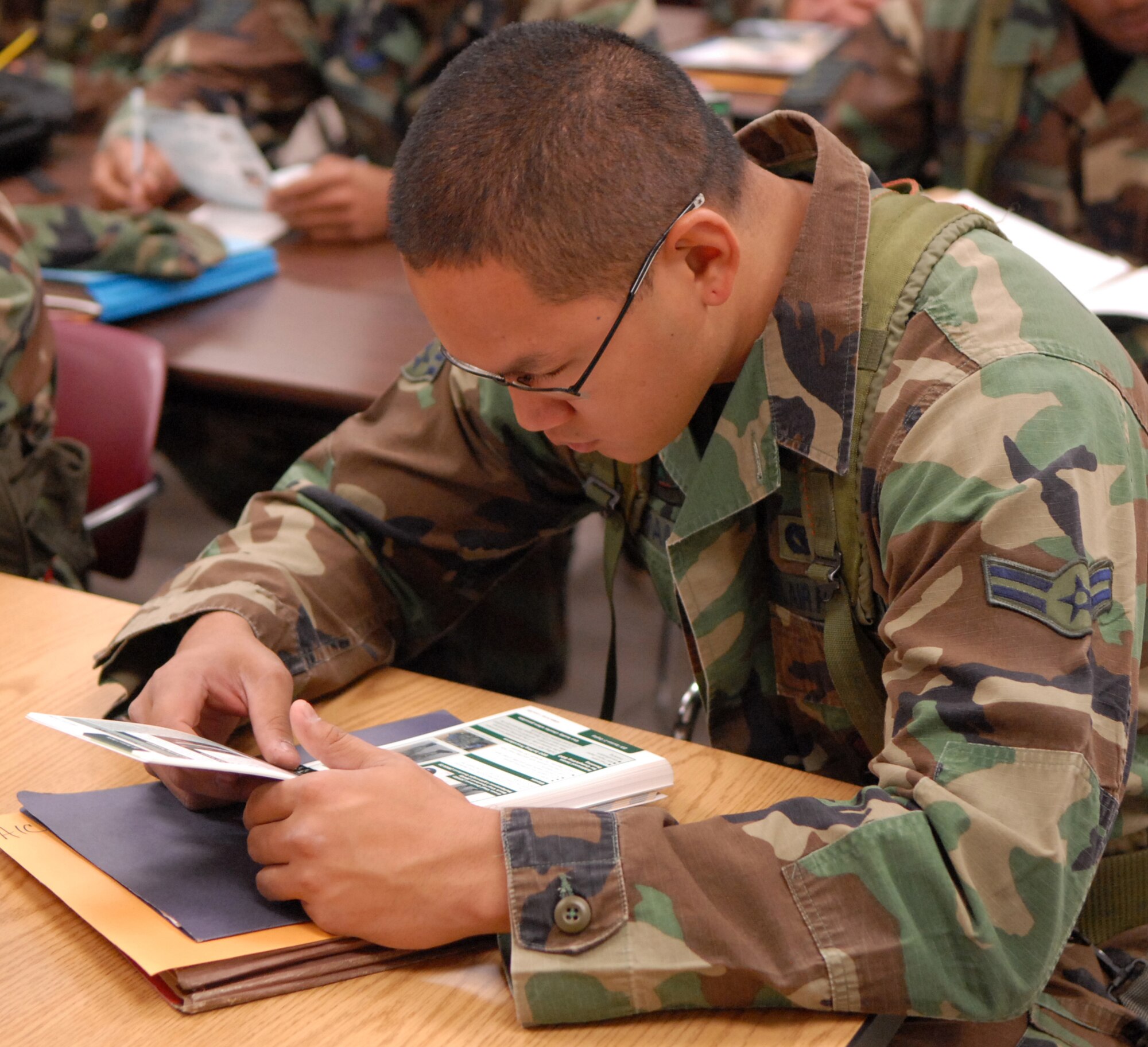 Airman First Class Justin Tayamen along with other Luke members, study their Airman Manual prior to a simulated deployment briefing for exercise Crown Talon 08-02, May 14, Luke Air Force Base, Ariz. Airman Tayamen is a power production apprentice from the 56th Cvil Engineer Squadron. (U.S. Air Force photo/Staff Sergeant Jerry Fleshman)