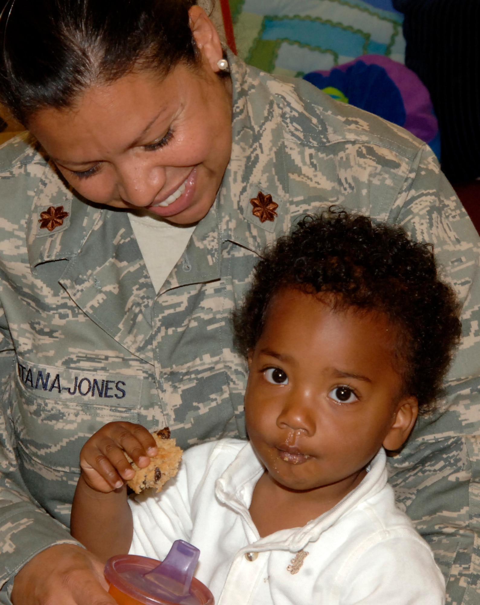 MCCONNELL AIR FORCE BASE, Kan. -- Maj. Xiomara Santana-Jones, 22nd Aerospace Medicine Squadron, helps her 17 month old son, Jared, eat his raisin-oatmeal cookie at the Child Development Center, May 08. After waking up from their afternoon naps, the children at the CDC enjoyed time spent with their mothers eating fresh cookies and lemonade. (Photo by Senior Airman Laura Suttles)