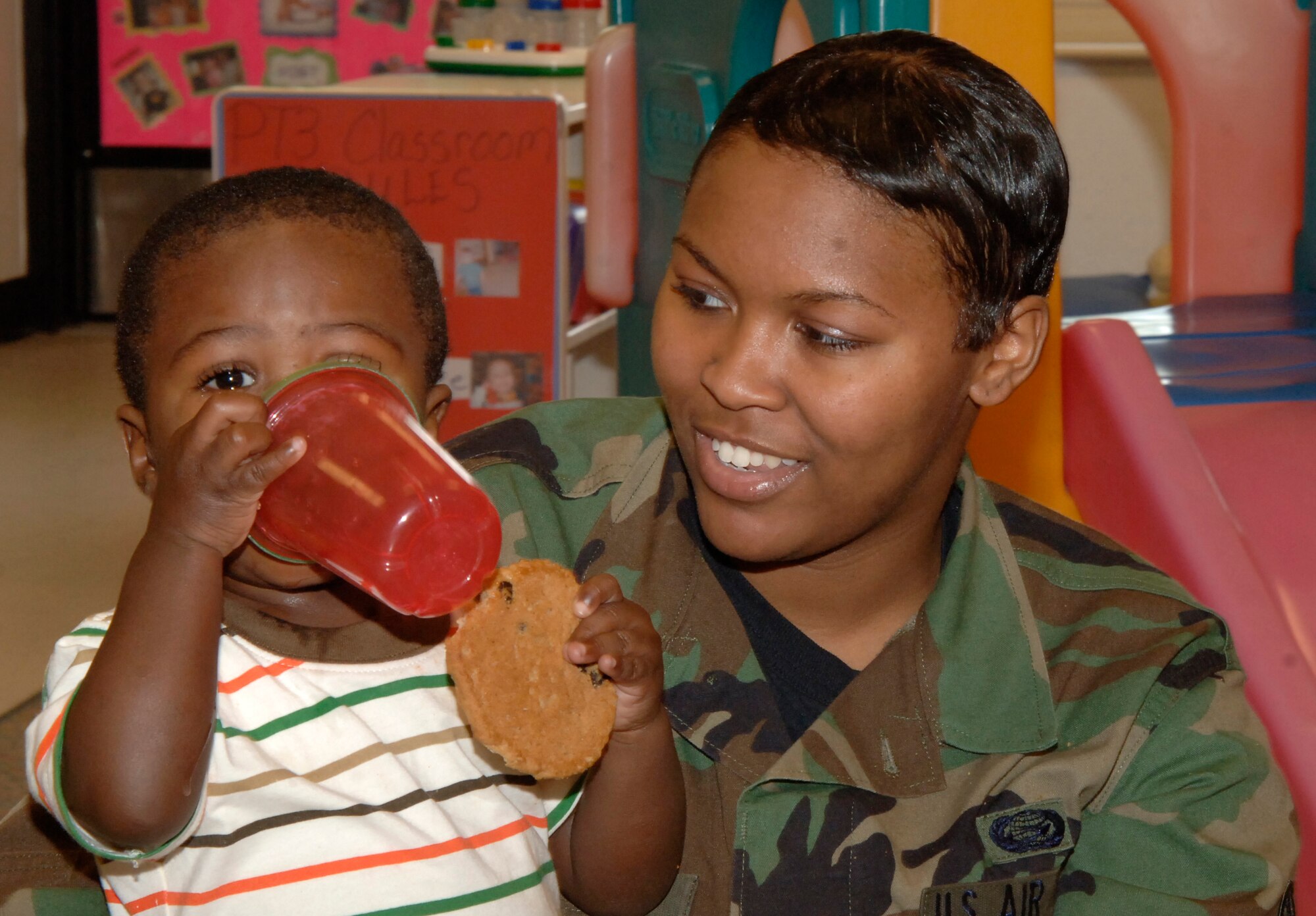 MCCONNELL AIR FORCE BASE, Kan. -- Senior Airman Casha Dees, 22nd Mission Support Squadron, visits her son Dylan, 15 months, at the Child Development Center for lemonade and cookies, May 08. Dylan is one of many children in the pre-toddler classrooms who participated in an early Mother’s Day Celebration. (Photo by Senior Airman Laura Suttles)