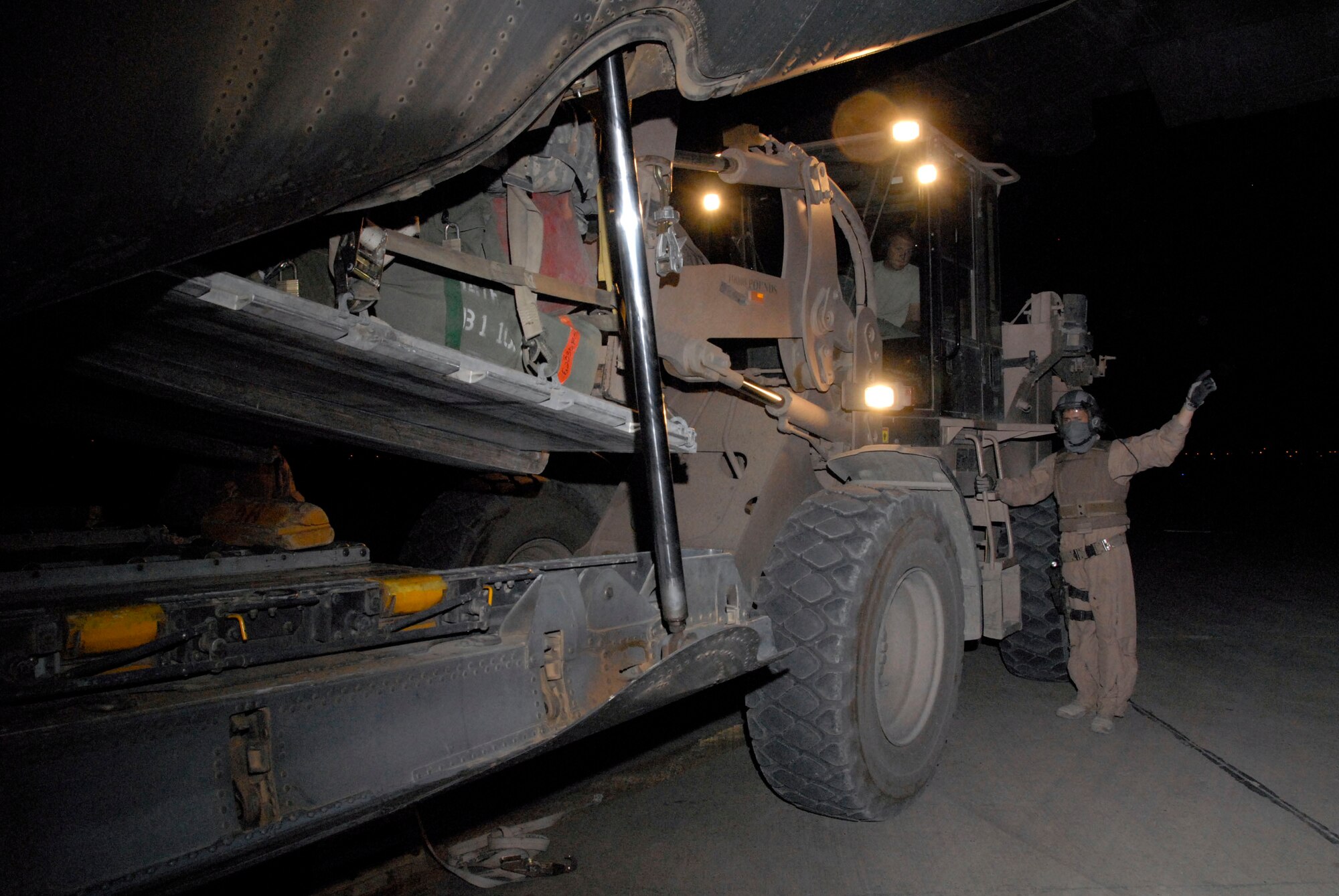 SOUTHWEST ASIA -- Staff Sgt. Gabriel Molanders, an Air Force C-130 Hercules loadmaster with the 737th Expeditionary Airlift Squadron, martials in Airman 1st Class Bryan Rogers, an aerial porter with the 447th Air Expeditionary Group, who's delivering a baggage pallet for a group of Soldiers from Fort Benning, Ga., departing Iraq on May 13, 2008. Sergeant Molanders is deployed from Dyess Air Force Base, Texas and Airman Rogers is deployed from McGuire AFB, N.J. (U.S. Air Force photo/Tech. Sgt. Michael O'Connor)