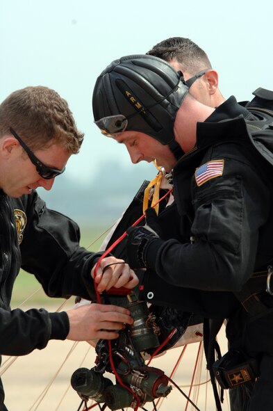 BARKSDALE AIR FORCE BASE, La. -- U.S. Army Staff Sgt. Ben Borger helps Staff Sgt. Justin Blewitt remove a smoke chain after sky diving during the U.S. Army Golden Knights performance at the opening ceremony of the Barksdale Air Force Base 2008 Defenders of Liberty Air Show.  The Air Show commemorates the 75th anniversary of Barksdale Air Force Base.  (U.S. Air Force photo by TSgt Laura K. Smith)