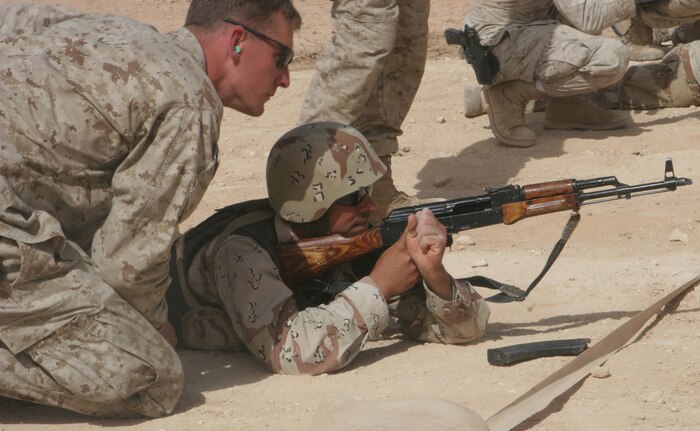 Cpl. Hunter R. Smith, 24, from Chandler, Ariz., who is a rifleman with Heliborne Assault Platoon, Regimental Combat Team 5, coaches an Iraqi soldier as he takes aim on targets at a range on Al Asad Air Base, Iraq, May16. The soldiers train and operate with the Marines to assist them in assault missions. The training they receive is an effort to organize a program where eventually the Iraqis will be equipped to conduct their own advanced training.