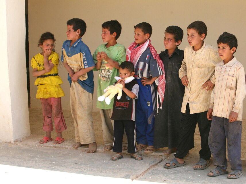 Local children gather outside their classroom to greet Marines from 3rd Marine Aircraft Wing (Forward) as the Marines visit the school to perform an inspection of the progress of the school’s improvements. The children were attending math class in a freshly painted, air-conditioned classroom before the Marines arrived today.